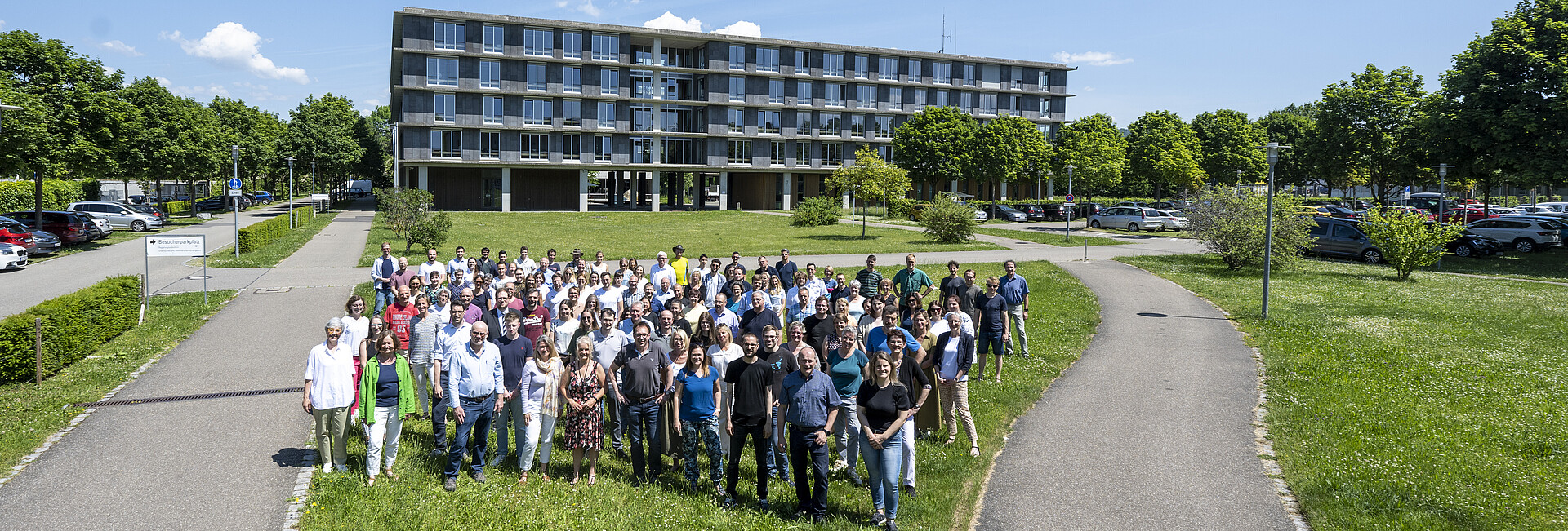 Mitarbeitende des RPs stehen vor einem der Dienstgebäude