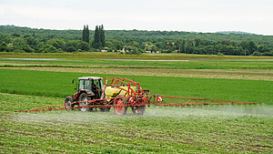 Landwirt mit Traktor Landwirt mit Traktor sprüht Pestizide oder Dünger auf das Feld